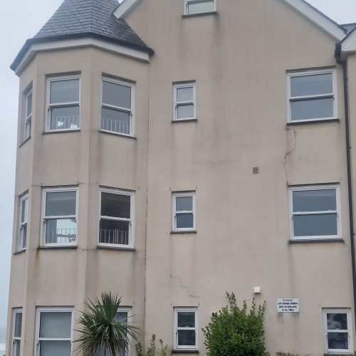 Before image of dirt on render walls of apartment block.